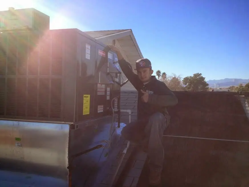 HVAC technician performing HVAC Inspection on a rooftop unit in Live Oak