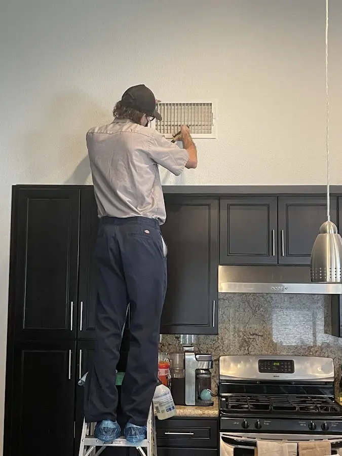 Technician inspecting an air vent during HVAC service in Live Oak